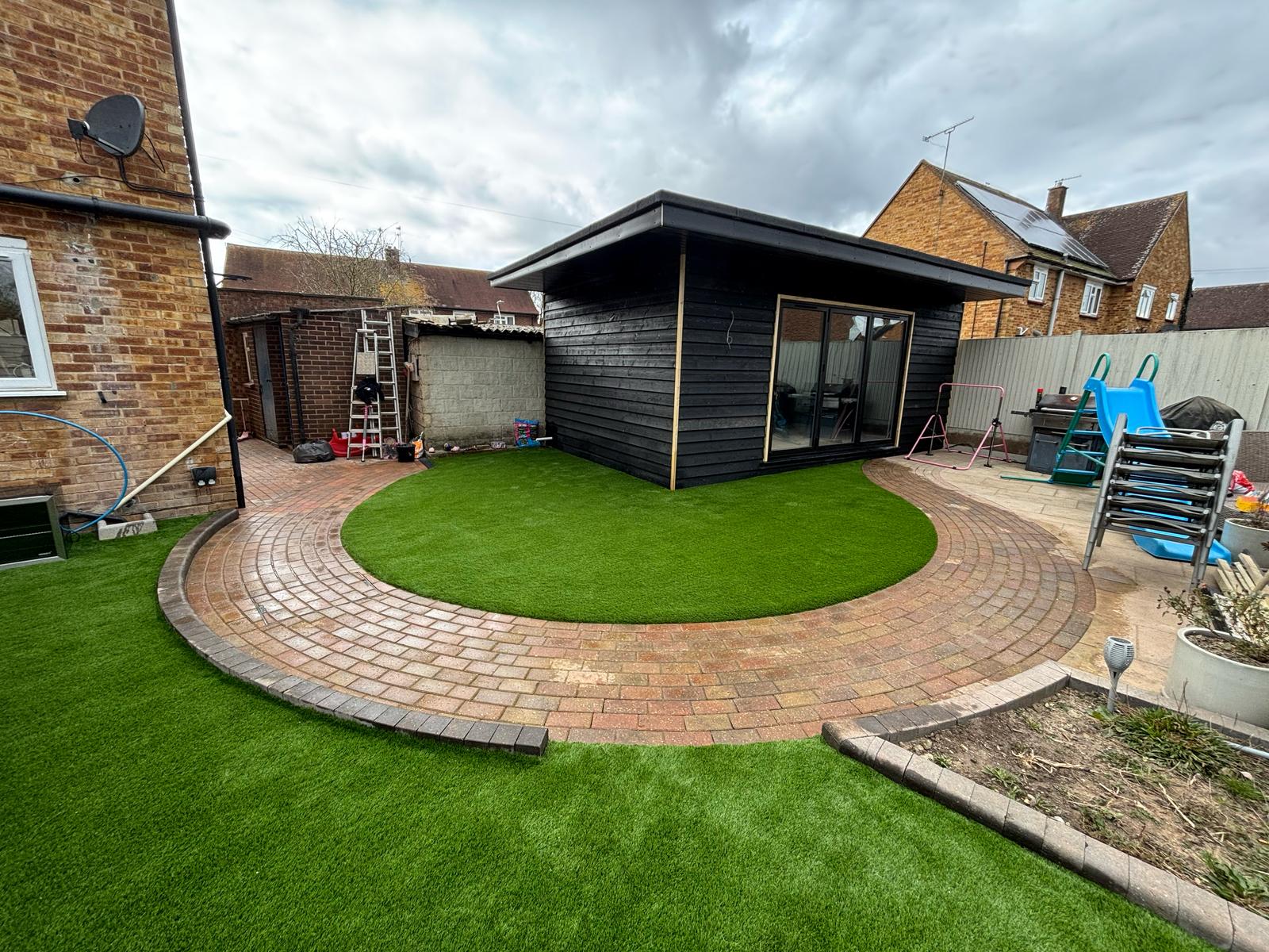 Curved lawn with garden office in Epsom