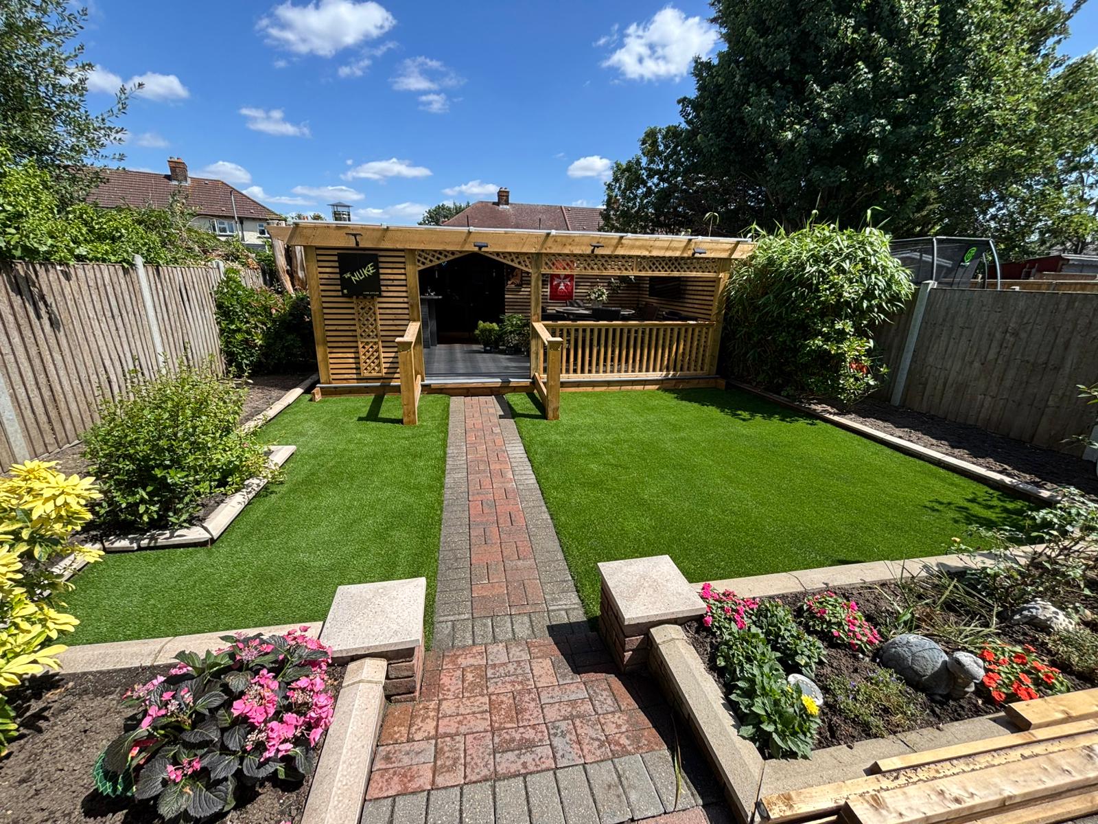 Pergola garden with flower beds in Finchley